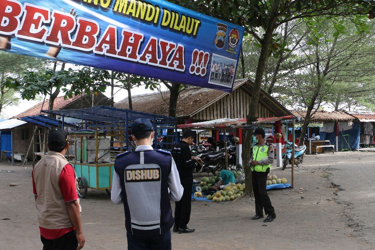 Polisi memasang spanduk berisi imbauan kepada pengunjung pantai di Kebumen, Jawa Tengah, beberapa waktu lalu.