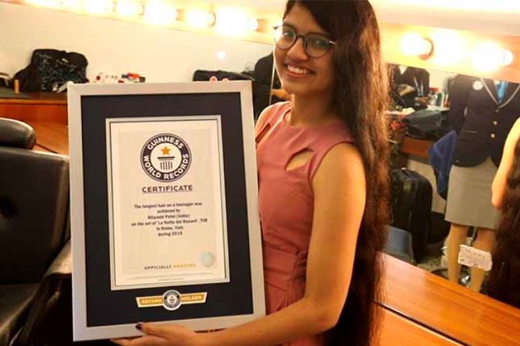 Nilanshi Patel (16) menunjukkan sertifikat pemegang rekor dunia Guinness sebagai remaja pemilik rambut terpanjang.