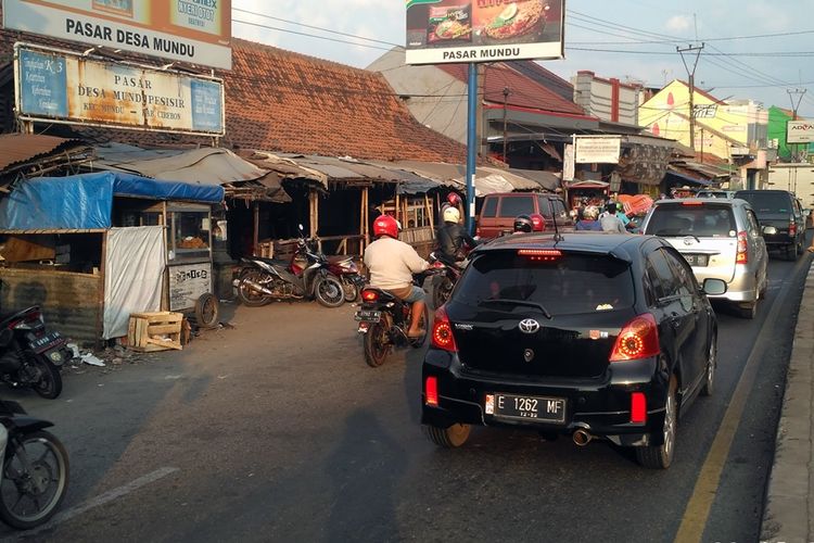 Sejumlah kendaraan roda dua dan empat melintas di depan Pasar Mundu, Kecamatan Mundu, Kabupaten Cirebon, Jawa Barat, Rabu (22/5/2019). Pasar tradisional lima ini juga berpotensi menjadi titik hambatan para pemudik. 