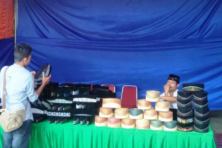 Pembeli memilih peci motif Aceh di Lapangan Jenderal Sudirman, Kota Lhokseumawe, Aceh, Senin (26/8/2019).
