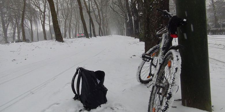 Bersepeda di tengah salju yang menyelimuti kota Brussel, Belgia, Jumat (2/3/2018). Ketebalan salju sekitar 10 cm dengan empasan angin dingin.