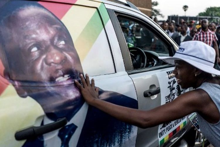 Warga Zimbabwe pendukung pemerintahan baru menyentuh gambar calon presiden baru Emmerson Dambudzo Mnangagwa.