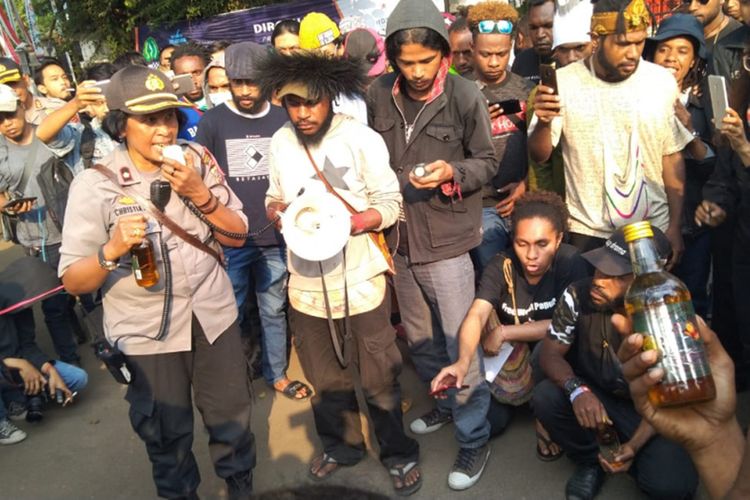 Para mahasiswa asal Papua saat menyerahkan kiriman minuman keras dari oknum polisi dalam aksi solidaritas di Gedung Sate, Jalan Diponegoro, Kamis (22/8/2019).