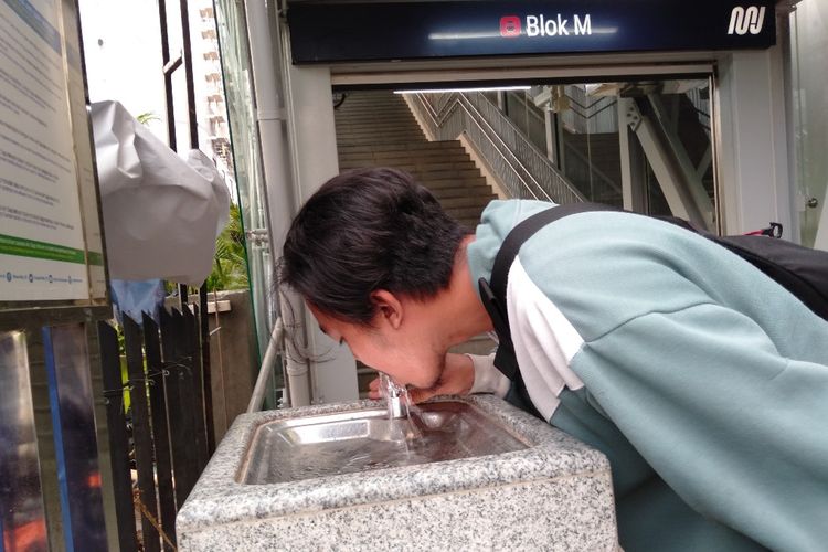 Seorang warga mencoba fasilitas air keran yang bisa langsung diminum secara gratis di Stasiun MRT Blok M, Rabu (10/4/2019)