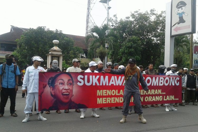 Elemen muslim Solo Raya yang tergabung dalam DSKS membawa poster Sukmawati dalam aksi damai di depan Mapolresta Surakarta di Jalan Adi Sucipto Manahan, Solo, Jawa Tengah, Jumat (6/4/2018).