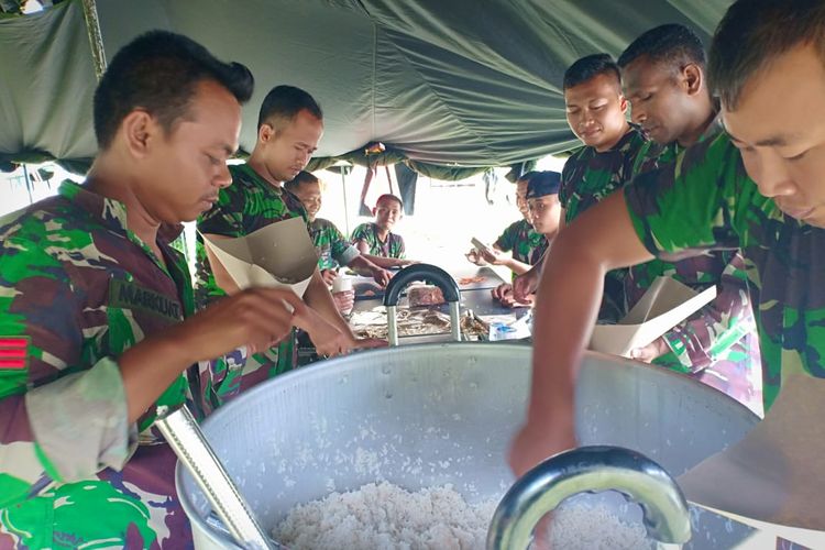 Prajurit TNI dari Satuan Perbekalan dan Anggukatan Kodam 17 Cenderawasih tengah menyiapkan makanan pengungsi, Senin (18/3/2019) 