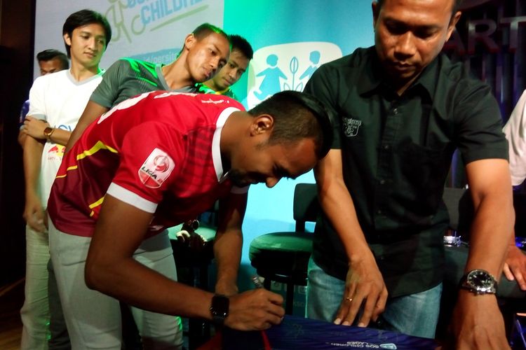 Penjaga gawang Persita Tangerang Annas Fitranto (kostum merah) menandatangani jersey klub sebagai bagian dari kerja sama dengan SOS Childrens Villages di Jakarta, Rabu (3/7/2019).
