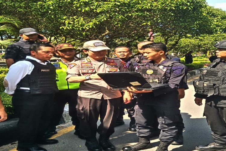 Petugas kepolisian saat tengah melakukan koordinasi setelah berhasil mengamankan kotak mencurigakan di depan rumah jabatan Kejaksaan Tinggi Kalimantan Tengah.