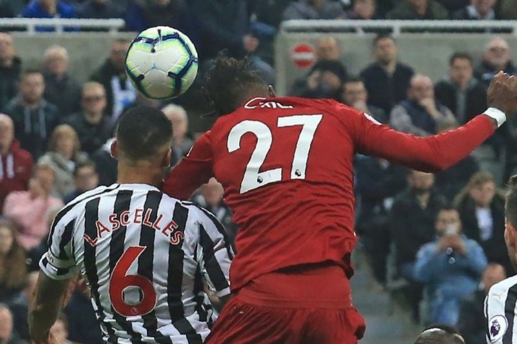 Divock Origi bergerak lebih cepat daripada Jamaal Lascelles dalam menyundul bola pada laga Newcastle United vs Liverpool dalam lanjutan Liga Inggris, 4 Mei 2019. 