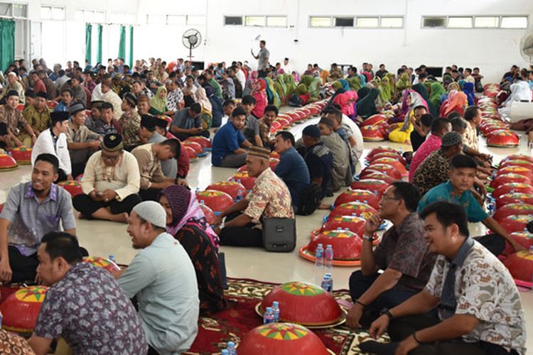 Duduk sama rendah menghadap dulang yang berisikan makanan.