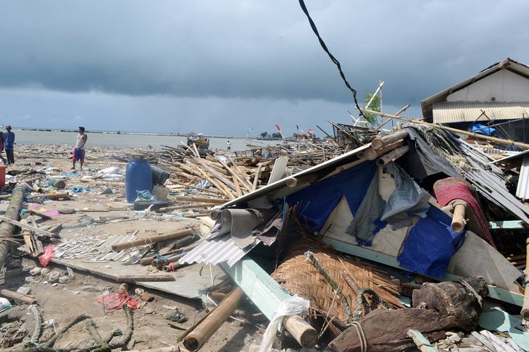Warga melintas di Tempat Pelelangan Ikan (TPI) yang rusak akibat tsunami Selat Sunda di Kampung Nelayan, Labuan, Pandeglang, Banten, Selasa (25/12/2018). BNPB (Badan Nasional Penanggulangan Bencana) melaporkan hingga Selasa (25/12) pagi jumlah korban meninggal dunia akibat tsunami Selat Sunda mencapai 481 orang, 1.216 orang luka, dan 67 orang lainya dinyatakan masih hilang. ANTARA FOTO/Muhammad Bagus Khoirunas/aww.
