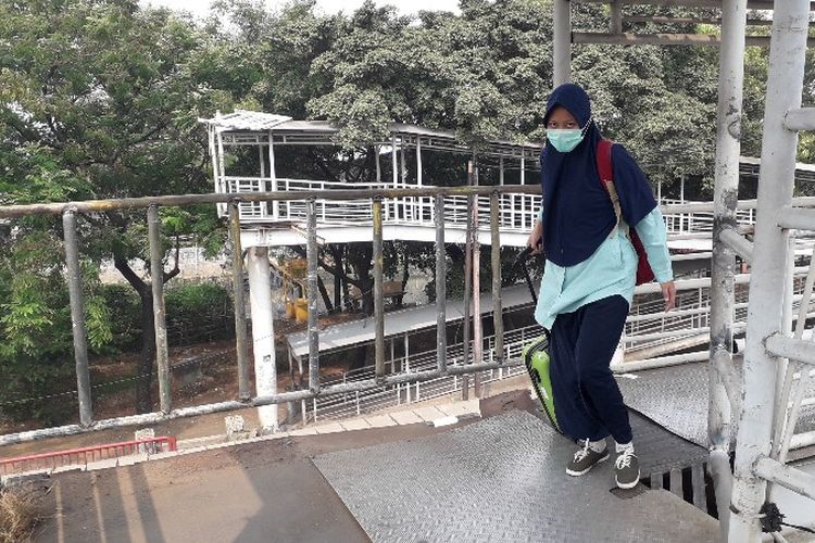 Seorang pengguna melintasi Jembatan Penyebrangan Orang (JPO) Daan Mogot, Cengkareng, Jakarta Barat pada Jumat (27/7/2018) setelah perbaikan lubang dan keropos. 