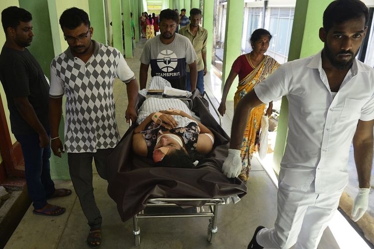 Seorang perempuan yang terluka dibawa dengan tandu di sebuah rumah sakit usai ledakan bom di sebuah gereja di kota Batticaloa, Sri Lanka, Minggu (21/4/2019). 