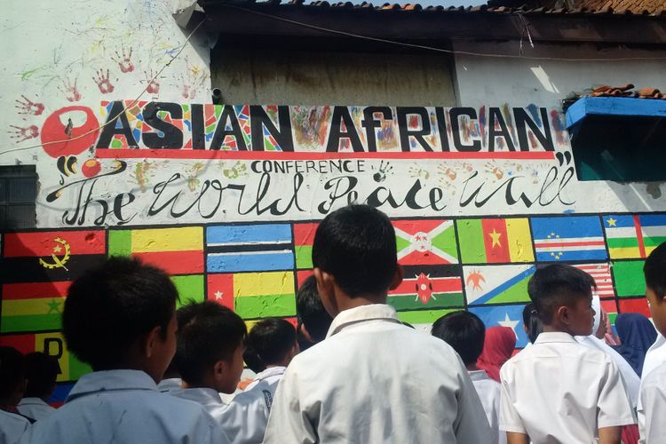 Tampak Para siswa tengah menghadap dinding yang dinamakan peace of wall yang berisikan 109 lukisan bendera Asia -Africa, Oceania, dan Australia. Lukisan ini diinisiasi Sekolah Rajat Iboe Inggit Garnasih di Jalan Lio Genteng, Nyengseret, Kecamatan Astana Anyar, Kota Bandung, Rabu (18/4/2018)
