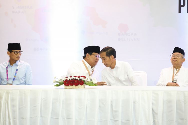 Dua calon presiden untuk Pemilu 2019, Prabowo Subianto (tengah kiri) dan Joko Widodo (tengah kanan), berbincang di tengah acara pengundian dan penetapan nomor urut capres-cawapres, di KPU, Jumat (21/9/2019)