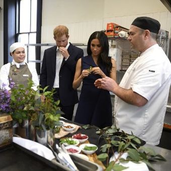 Pangeran Harry dan dan istrinya Meghan Markle mencicipi bahan makanan asli Australia di restoran perusahaan sosial di Melbourne pada Kamis (18/10/2018). (AFP/Andy Brownbill)