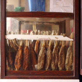 Warung Sampurna bisa menjual sate bandeng rata-rata 150
tusuk setiap hari (atas). Yus Aslah (54) sudah berjualan sate
bandeng sejak tahun 1974 (kiri).