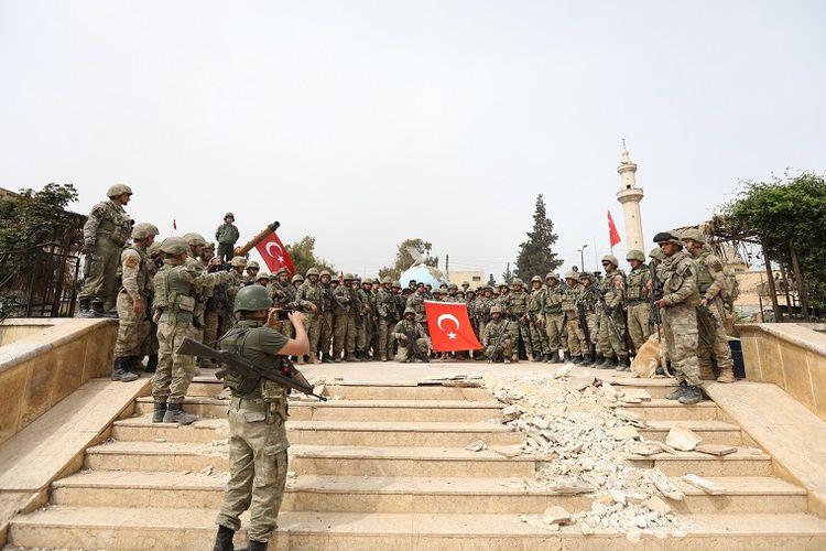 Pasukan Turki berfoto bersama setelah berhasil merebut kota Afrin, Suriah yang selama ini dikuasai milisi Kurdi pada Minggu (18/3/2018).
