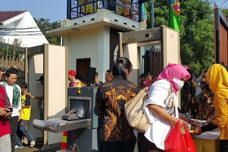 Ketatnya pengamanan masuk area Lebaran Betawi di PBB Setu Babakan, Minggu (30/7/2017). Warga harus diperiksa menggunakan metal detector jelang kedatangan Presiden Joko Widodo.