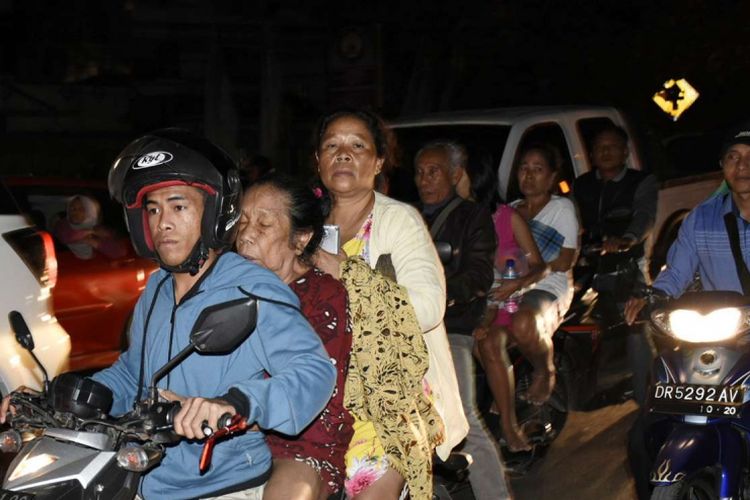 Warga yang panik menaiki sepeda motor ketika terjadi gempa bermagnitudo 7 di Kecamatan Ampenan, Mataram, NTB, Minggu (5/8/2018).