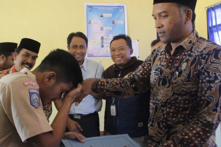 Lombok Timur, Kompas.Com- Aldi Irpan bersalaman  dengan Kepala Sekolahnya, Sadikin Ali, usai menerima surat kelulusan, Sabtu (25/6/2019) di SMAN 1 Sembalun.