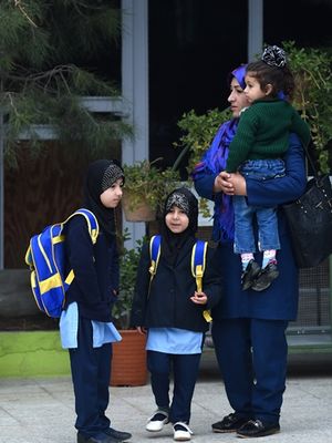 Maliha (kanan) menggendong putrinya Sama (3), sementara Sana (tengah, dan Dunya (kiri) berdiri di sampingya. (AFP/Wakil Kohsar)