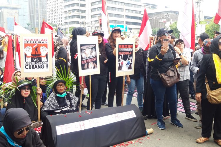 Sejumlah massa berunjuk rasa di depan Bawaslu RI sambil membawa keranda mayat, di depan Bawaslu RI, Jakarta Pusat, Rabu (15/5/2019)
