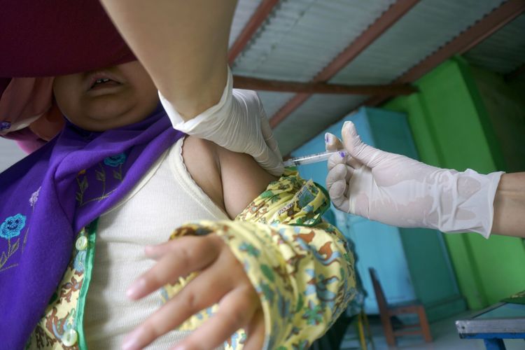 Petugas medis menyuntikkan vaksin MR (measles and rubella) kapada siswa TK di Tulungagung, Jawa Timur, Rabu (9/8/2017). Imunisasi MR untuk 120 ribu anak kelompok umur minimal sembilan bulan, TK-SD-SMP dengan rentang usia kurang dari 15 tahun untuk mencegah infeksi campak dan rubella melalui saluran pernafasan di Tulungagung ditargetkan tuntas bertahap hingga akhir September 2017. ANTARA FOTO/Destyan Sujarwoko/kye/17