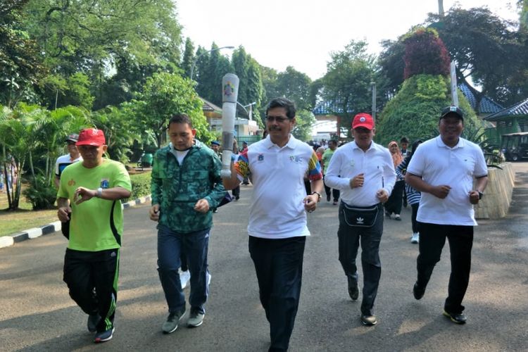 Wali Kota Jakarta Selatan Marullah Matali berlatih lari membawa replika obor Asian Games prosesi Torch Relay Asian Games 2018 di kawasan Taman Margasatwa Ragunan, Jumat (20/7/2018).