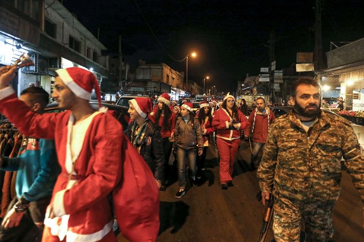 Warga berpakaian seperti Sinterklas berpawai di jalanan ibu kota Damaskus karena merayakan Malam Natal pada Senin (24/12/2018) dengan pengawalan pasukan Suriah.