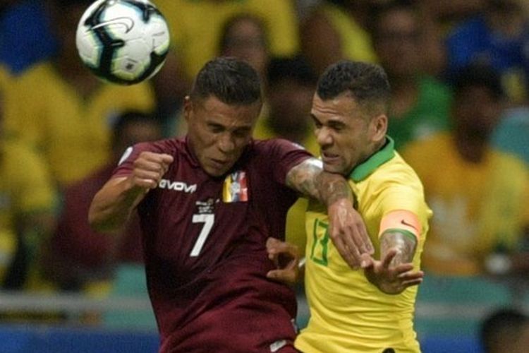 Bek timnas Brasil, Dani Alves, berusaha merebut bola yang disundul pemain Venezuela, Darwin Machis, pada laga Copa America di Fonte Nova Arena, Salvador, Brasil, 18 Juni 2019.