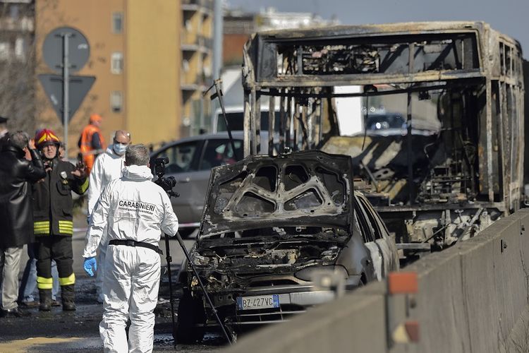 Petugas forensik bekerja di lokasi bus yang terbakar dalam aksi penyanderaan oleh sopir bus sekolah di Italia, Rabu (20/3/2019).