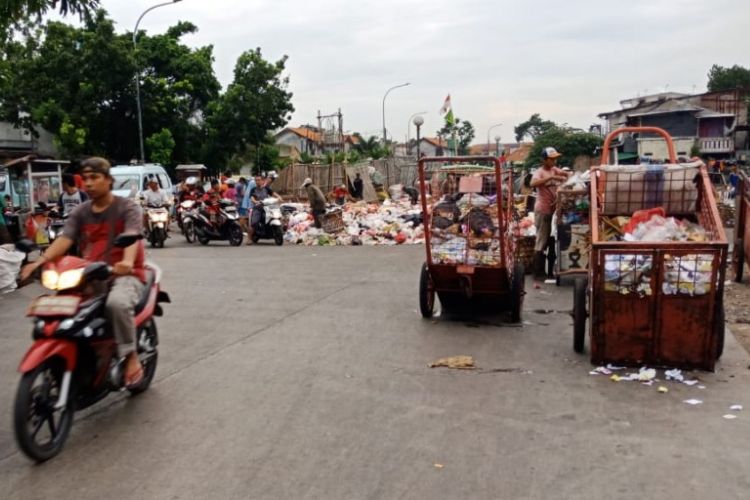 Sampah menumpuk dan meluber ke Jalan Bugis, Kebon Bawang, Jakarta Utara, Jumat (25/5/2018).