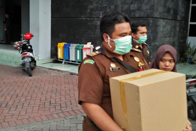 Petugas dari Kejari Gresik membawa beberapa barang bukti usai penggeledahan di BPPKAD Pemkab Gresik, Senin (14/1/2019) sore.