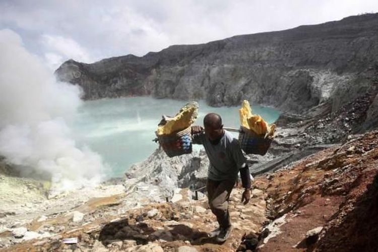 Marzuki, seorang petambang berjalan membawa bakul penuh bongkahan belerang, saat naik dari kawah Gunung Ijen di Banyuwangi, Jawa Timur, Sabtu (16/4/2016). Demi mendapat penghasilan yang terbilang minim, petambang harus menapaki gunung dengan memanggul puluhan kilogram bongkahan belerang di tengah asap beracun. 