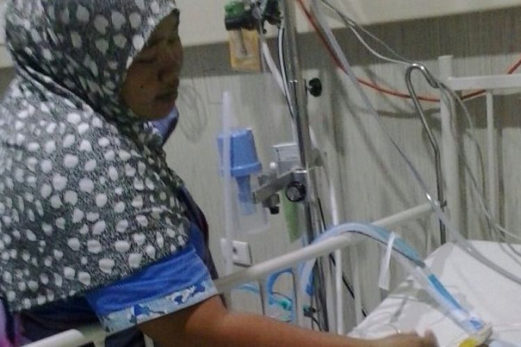Nuraidah tengah mengecek kondisi anaknya yang mengidap kelainan jantung dan infeksi paru di ruang PICU RS Bunda Thamrin, Jumat (9/2/2018). Pihak keluarga berharap uluran tangan dari berbagai pihak. 