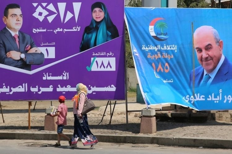 Seorang ibu dan anaknya melewati baliho yang memperlihatkan mantan Perdana Menteri Irak Ayad Allawi (kanan) dan kandidat lainnya dalam Pemilu Parlemen 12 Mei mendatang.