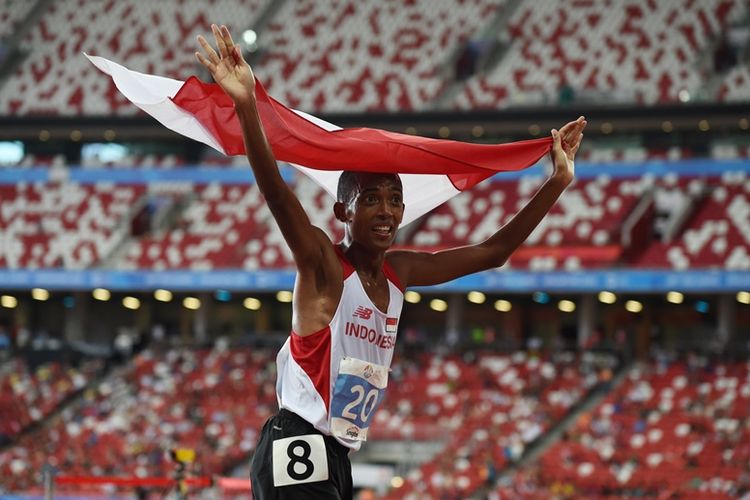 Pelari Indonesia, Agus Prayogo, mengibarkan bendera Indonesia setelah mencapai garis finis lomba lari 10.000 meter SEA Games 2015 di Singapura, 10 Juni 2015.