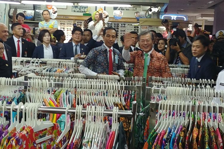 Presiden Joko Widodo dan Presiden Korsel Moon Jae-in menjajal batik di salah satu toko di Bogor Trade Mall di Bogor, Jawa Barat, Kamis (9/11/2017).