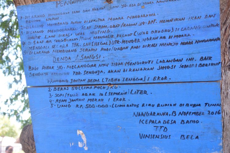 Papan pengumuman yang ditempelkan di pohon asam di Nangarawa dari Pemerintah Desa Bamo untuk melarang warga menangkap ikan dan biota lainnya di Limbu Mbupu Lea dan Amu, Minggu (28/10/2018).