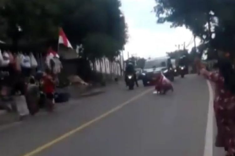 Seorang ibu merebahkan diri di tengah jalan menyetop mobil presiden Jokowi saat berkunjung ke Lombok, Jumat (17/5/2019).