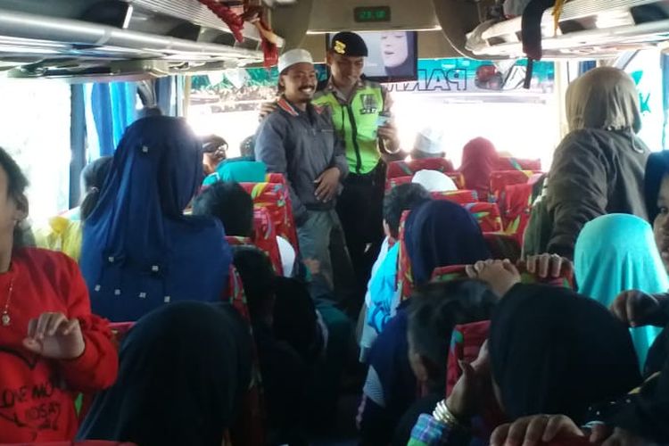 Salah satu anggota Polres Malang saat merazia bus di pintu masuk Tol Pandaan-Malang, Rabu (26/6/2019)
