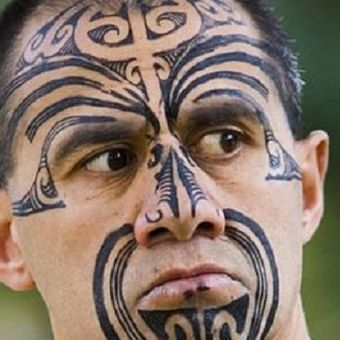 Seorang pria Maori dengan tato di wajahnya.