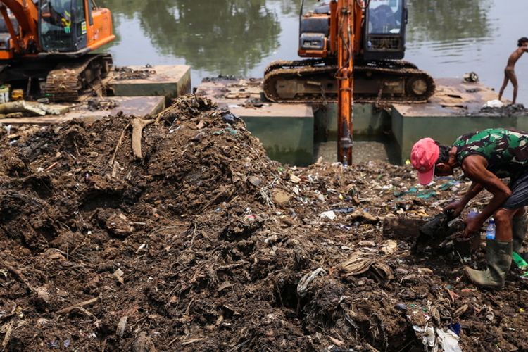 Sejumlah warga mencari sampah berupa besi saat pekerja mengeruk lumpur menggunakan ekskavator di Kanal Banjir Barat (KBB) sungai Ciliwung di Tanah Abang, Jakarta Pusat, Senin (11/9/2017). Pengerukan lumpur dilakukan untuk memperlancar aliran air sungai serta mengantisipasi datangnya musim hujan yang mengakibatkan banjir yang kerap terjadi di Jakarta.