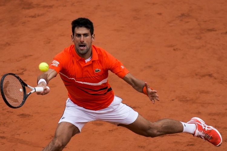 Novak Djokovic mencoba mengembalikan bola pukulan Dominic Thiem pada partai semifinal French Open 2019, 7 Juni 2019. 