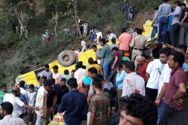 Warga melihat bangkai bus yang terjatuh ke dalam ngarai di Nurpur, negara bagian Himachal Pradesh, utara India, Senin (9/4/2018).