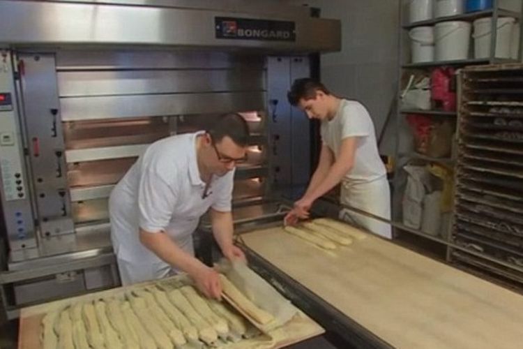 Cedric Vaivre (kiri) sedang membuat roti bersama seorang karyawannya.