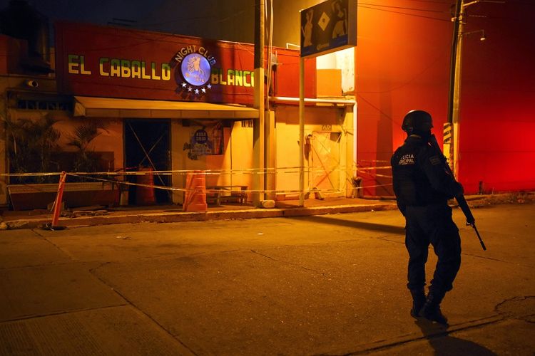 Polisi bersenjata berjaga di luar bar dan klub penari telanjang Caballo Blanco yang menjadi sasaran penyerangan dan pembakaran di kota Coatzacoalcos, negara bagian Veracruz, pada Selasa (28/8/2019) malam.
