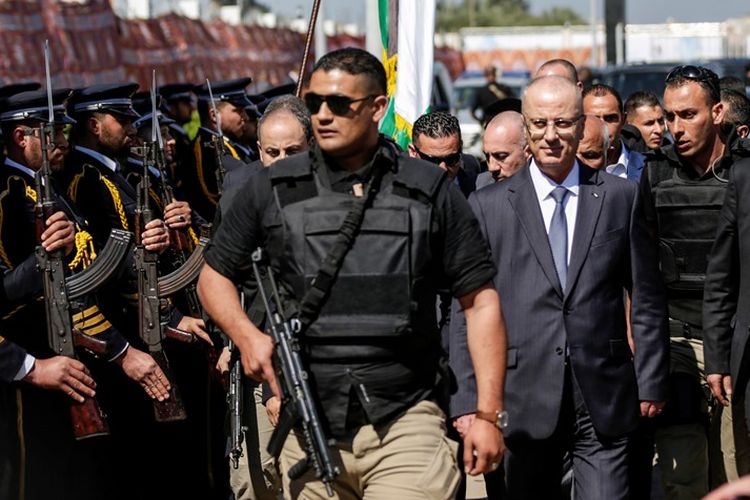 Perdana Menteri Palestina Rami Hamdallah (dua dari kanan) dikawal ketat saat tiba di Gaza, Selasa (13/3/2018).