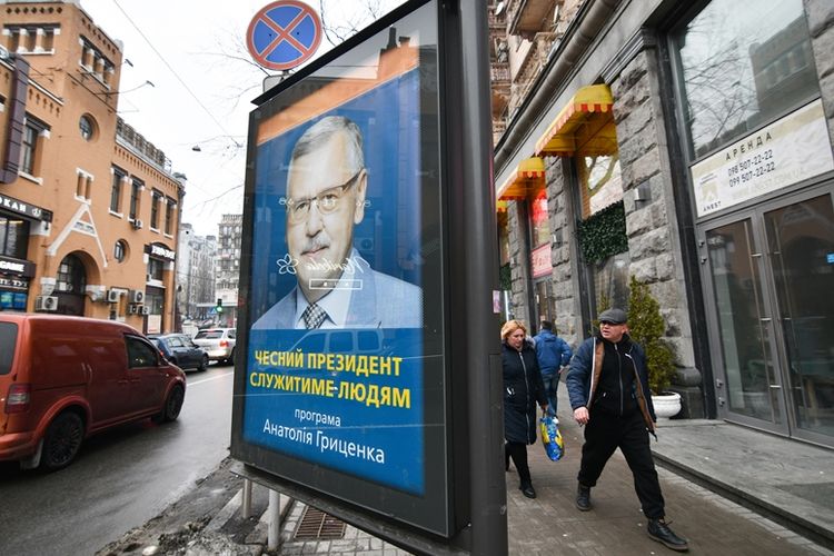 Warga melintas di dekat sebuah poster kandidat presiden di Kiev. Ukraina dijadwalkan menggelar agenda pemilihan presiden pada 31 Maret 2019.